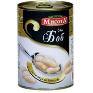 The image shows a can with Bulgarian text. The can features a label with a black and gold color scheme. There is an image of a spoon filled with white beans. The brand name is prominent in red and green on a white background. The product is identified as containing white beans, and the label highlights guaranteed quality.