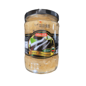 The image shows a glass jar with a black lid containing a food product. The label on the jar features an image of eggplants and includes text in a language using the Cyrillic alphabet. The brand name is highlighted in red. The jar appears to contain a blended or mashed substance, likely related to eggplants. There are also date markings printed on the jar.
