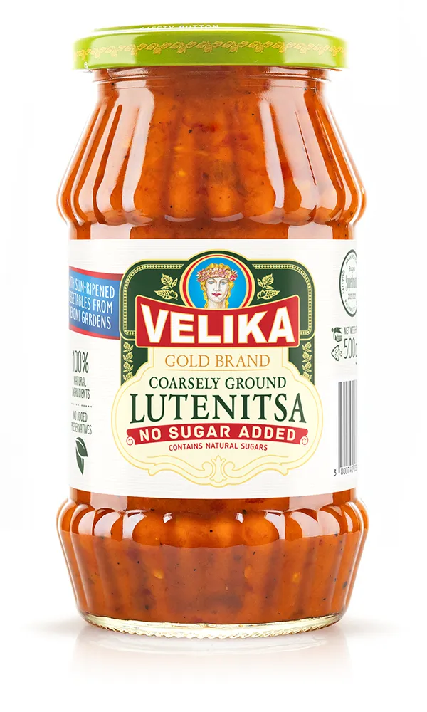 The image shows a jar of Velika brand coarsely ground lutenitsa. The jar has a green lid and a detailed label. The label features the product name Lutenitsa prominently in bold red letters. It mentions no sugar added and contains natural sugars beneath the product name. The label also highlights 100% natural ingredients and no added preservatives. The lutenitsa inside the jar appears to be a chunky, red-orange mixture.