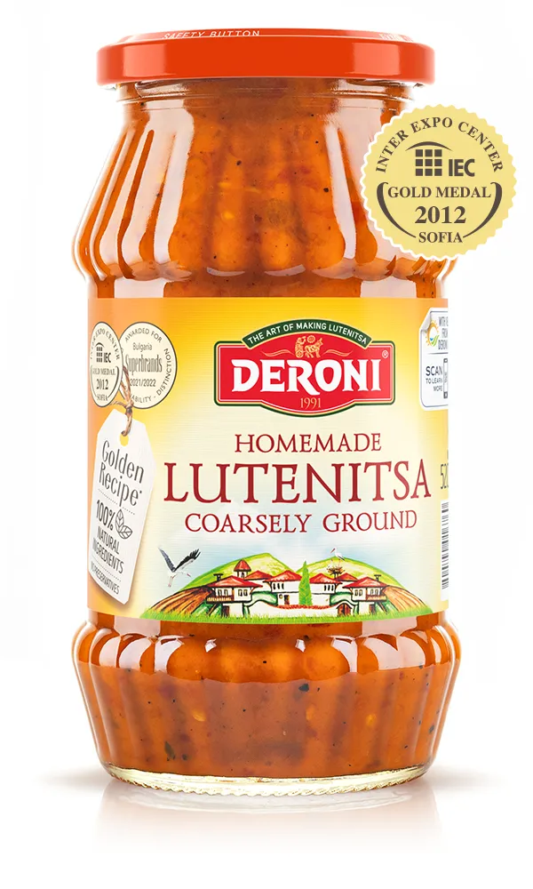 The image shows a jar of Deroni Homemade Lutenitsa, which is a coarsely ground type of spread. The jar has a red lid and a label featuring a picturesque illustration of a village with houses and hills. The label highlights 100% natural ingredients and includes a gold medal emblem from the Inter Expo Center, awarded in 2012 in Sofia. The brand Deroni is prominently displayed in red lettering, and the jar has a safety button indication on its lid.