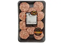 The image shows a package containing a tray of raw meat patties. There are nine patties arranged in three rows. The packaging is clear plastic, allowing the patties to be visible. There is a label in the center with branding and product information, along with a “Premium Selection” badge. The patties appear to be uncooked and are pinkish in color.