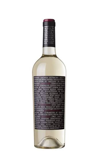 The image shows a bottle of white wine with a long, cylindrical shape and a dark label. The label displays text written in white on a dark background, covering most of the front of the bottle. The text continues onto the neck of the bottle. The wine inside appears pale yellow, and the bottle is topped with a dark-colored capsule.