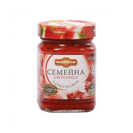 The image shows a glass jar of Lyutenitsa, a traditional Bulgarian relish. The jar has a red label featuring Cyrillic text and a decorative design. The lid is also red with a pattern. It indicates the product is 265g and highlights some qualities like без (meaning without) which might refer to preservatives or additives. The design suggests a focus on traditional or family-style preparation.