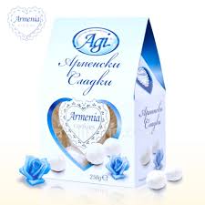 The image shows a package of sweets branded as Armenia. The packaging is primarily white and blue, featuring a heart-shaped design in the center. The brand name Agi is at the top, and there is decorative text in what appears to be a Cyrillic script. The packaging includes visual elements like roses and a window revealing the sweets inside. The weight indicated is 250g.