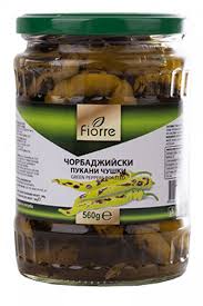 The image shows a jar with a green lid containing pickled green peppers. The label on the jar features the brand Fiore and displays the product name in Cyrillic, along with an image of green peppers. The net weight shown is 560 grams. The jar is filled with sliced, preserved peppers visible through the clear glass.