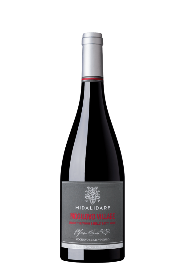 The image shows a bottle of wine with a silver cap. The label is gray with red and white text. It includes the name MOGILOVO VILLAGE in red, and states it contains Cabernet Sauvignon, Merlot, and Petit Verdot. The label also features the brand name MIDALIDARE, a decorative crest, and additional text indicating it is from a single vineyard.